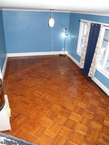 unfurnished dining area with crown molding and baseboards