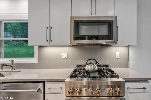 84 Burnham Pkwy, Morris Twp, NJ 07960 - kitchen featuring stainless steel appliances, decorative backsplash, white cabinetry, and light countertops