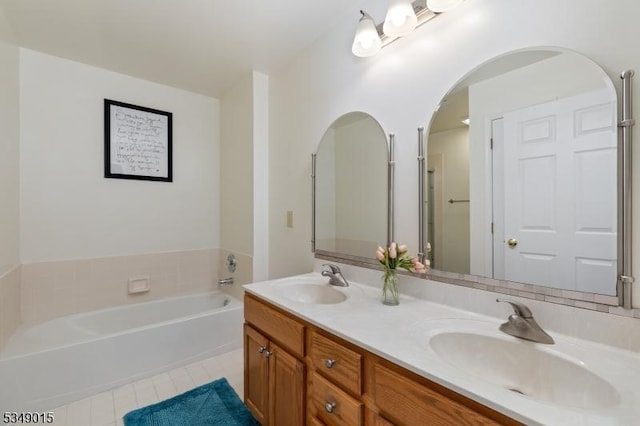 full bath featuring a sink, tile patterned floors, double vanity, and a bath