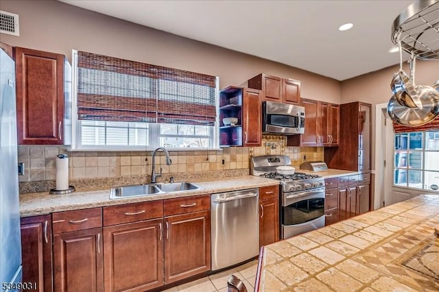 kitchen featuring stainless steel appliances, tasteful backsplash, visible vents, and a sink