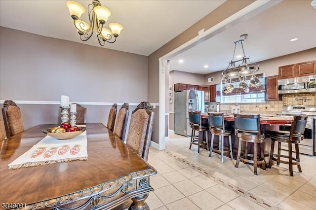 dining area featuring a chandelier, light tile patterned floors, baseboards, and recessed lighting