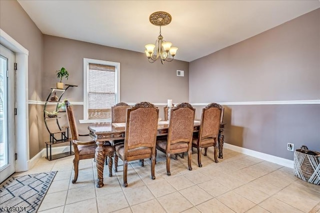 dining space with light tile patterned floors, a notable chandelier, and baseboards