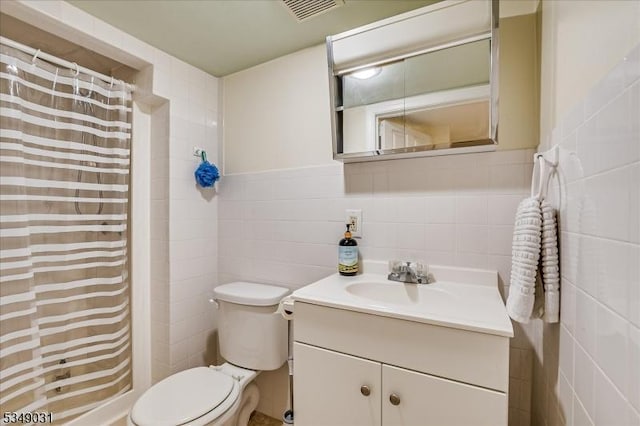 full bath with vanity, a shower with curtain, visible vents, toilet, and tile walls
