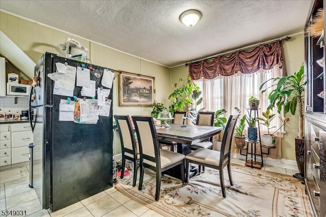 dining space with light tile patterned floors and a textured ceiling