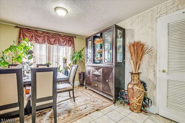 tiled dining area with a textured ceiling