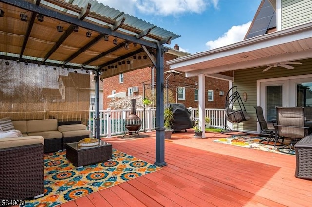 wooden terrace featuring grilling area, an outdoor hangout area, and a ceiling fan