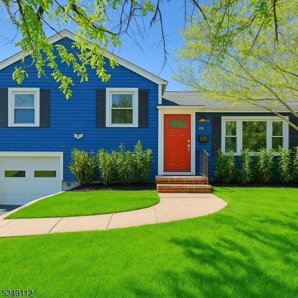 tri-level home featuring an attached garage and a front lawn