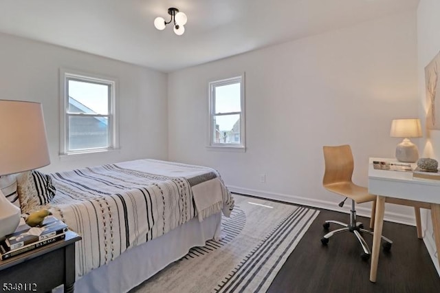 bedroom with baseboards and wood finished floors