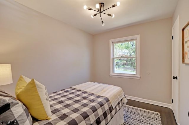 bedroom featuring baseboards, an inviting chandelier, and dark wood finished floors