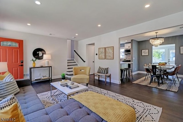 living area with an inviting chandelier, stairs, recessed lighting, baseboards, and wood finished floors