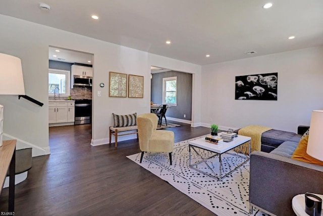 living room featuring recessed lighting, dark wood-style flooring, and a wealth of natural light