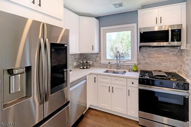 kitchen featuring visible vents, light countertops, white cabinetry, a sink, and stainless steel appliances