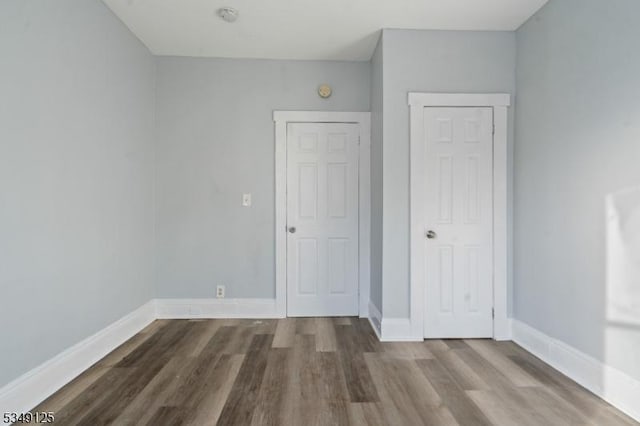 unfurnished bedroom featuring baseboards and wood finished floors