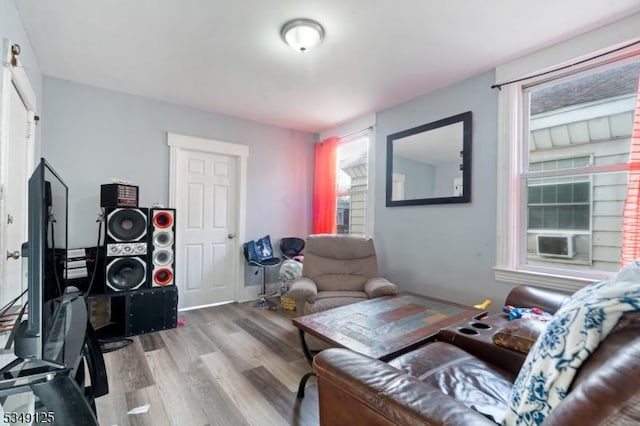 living room featuring plenty of natural light, wood finished floors, and cooling unit