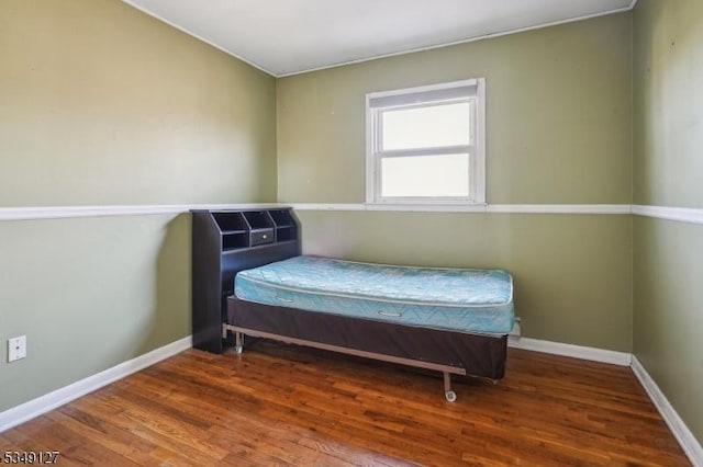 bedroom featuring wood finished floors and baseboards