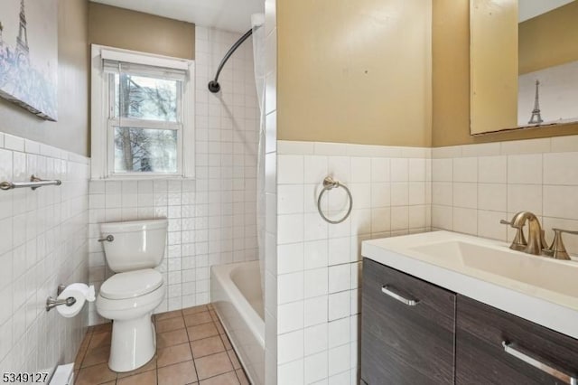 full bathroom featuring toilet, a wainscoted wall, tile patterned floors, tile walls, and vanity