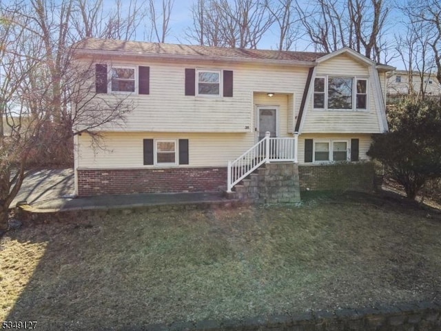 split foyer home with brick siding and a front yard