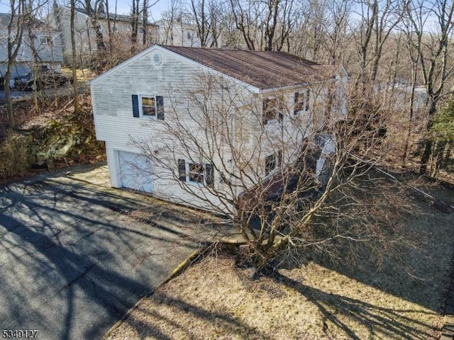 view of outbuilding featuring a garage and aphalt driveway