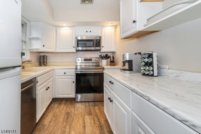 107 S Maple, Park Ridge Boro, NJ 07656 - kitchen featuring tasteful backsplash, white cabinetry, appliances with stainless steel finishes, a sink, and wood finished floors