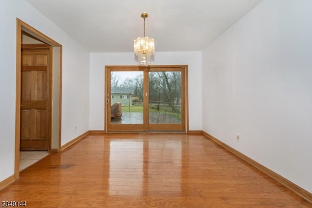 11 Stillwell Rd, South Brunswick Twp, NJ 08824 - spare room featuring wood finished floors, a chandelier, and baseboards