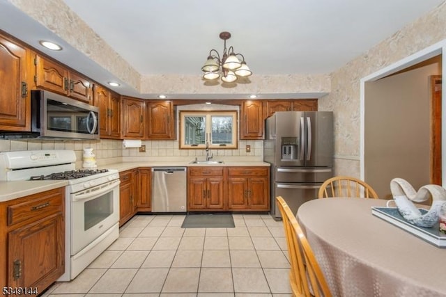 11 Stillwell Rd, South Brunswick Twp, NJ 08824 - kitchen with stainless steel appliances, a sink, a chandelier, light countertops, and brown cabinetry