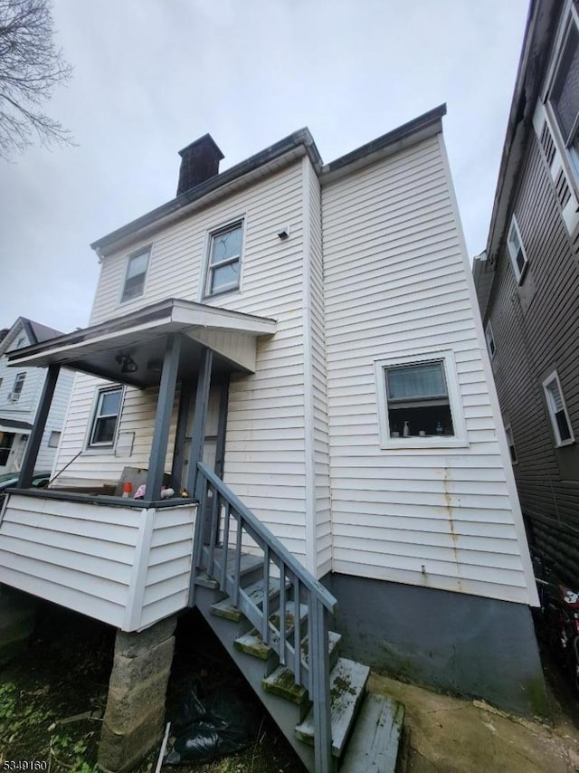 back of property with a chimney