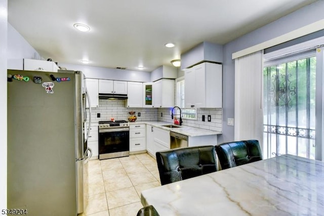 688 S 18th St, Newark City, NJ 07103 - kitchen featuring appliances with stainless steel finishes, a sink, backsplash, light tile patterned flooring, and light stone counters