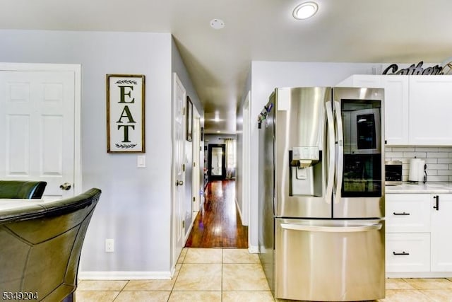 688 S 18th St, Newark City, NJ 07103 - kitchen with stainless steel refrigerator with ice dispenser, light tile patterned floors, white cabinets, and baseboards