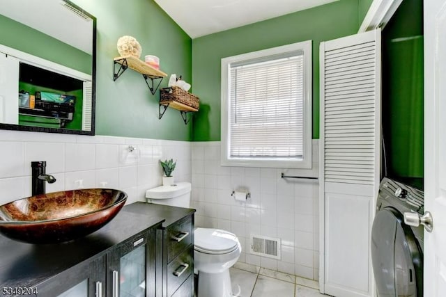 688 S 18th St, Newark City, NJ 07103 - bathroom featuring washer / clothes dryer, tile walls, toilet, vanity, and tile patterned floors