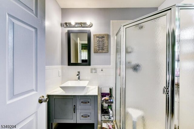 688 S 18th St, Newark City, NJ 07103 - bathroom featuring vanity, a shower stall, and tile walls