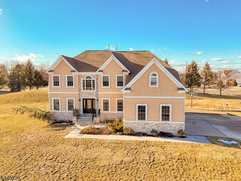2 Kristen Ct, Franklin Twp, NJ 08873 - view of front facade with stucco siding, stone siding, and a front yard