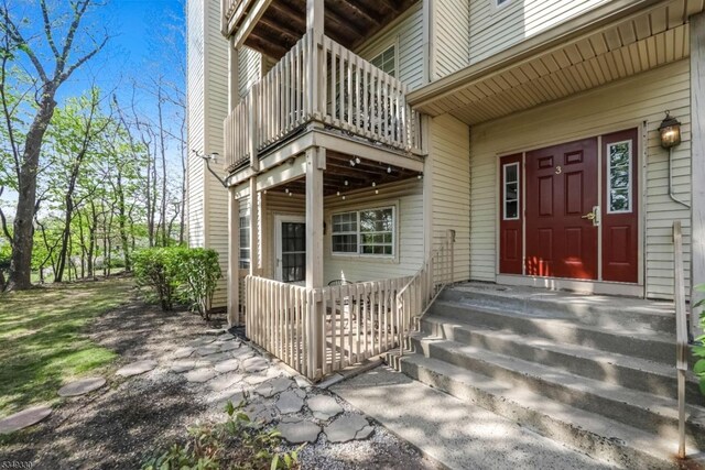 view of exterior entry with a balcony