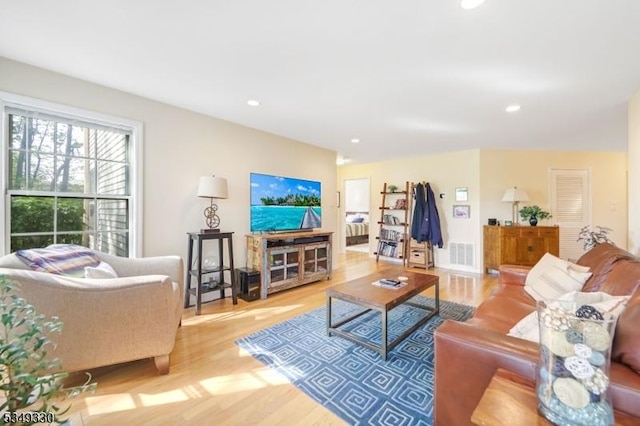 living area with recessed lighting, wood finished floors, and visible vents