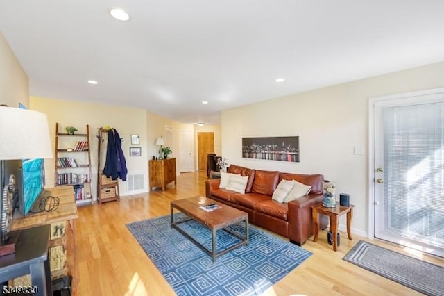 living area with recessed lighting, baseboards, visible vents, and light wood-style flooring