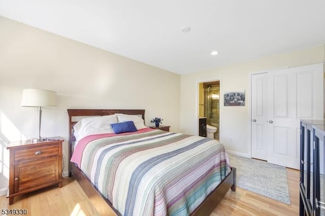 bedroom with recessed lighting, baseboards, light wood-type flooring, and ensuite bath