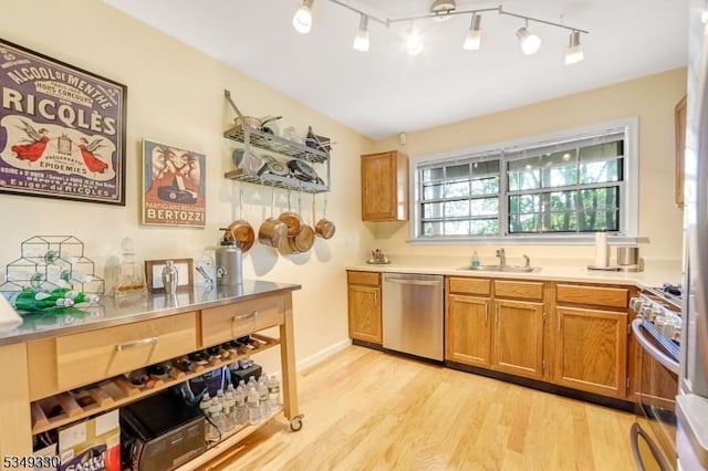 kitchen with brown cabinets, a sink, light countertops, light wood-style flooring, and stainless steel appliances