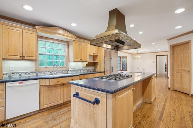 kitchen featuring stainless steel appliances, island exhaust hood, a sink, light brown cabinets, and ornamental molding