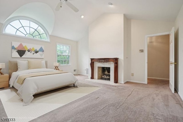 carpeted bedroom with a fireplace with flush hearth, baseboards, ceiling fan, and high vaulted ceiling