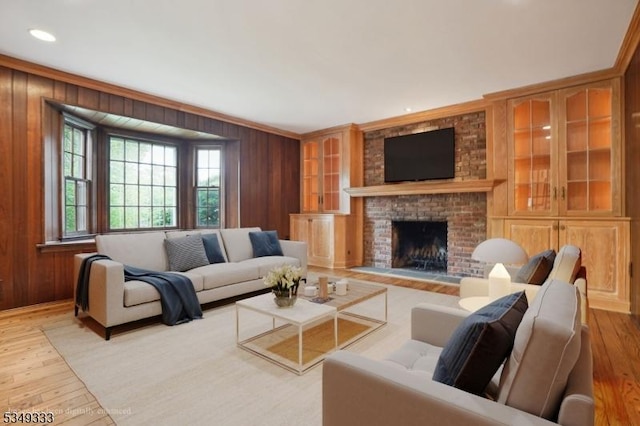 living room with wooden walls, wood-type flooring, a fireplace, and recessed lighting
