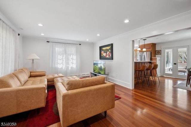 living area with crown molding, recessed lighting, french doors, and wood finished floors