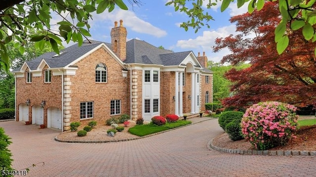 24 Glenview Dr, Warren Twp, NJ 07059 - view of front of house featuring a chimney, brick siding, driveway, and a garage