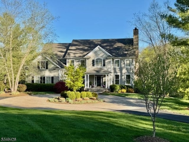 view of front of house with a front lawn and a chimney
