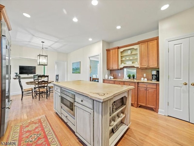 kitchen featuring light wood-style floors, open shelves, tasteful backsplash, and oven