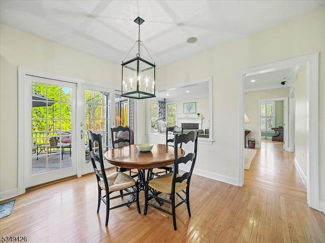 dining space with baseboards, an inviting chandelier, and light wood-style floors