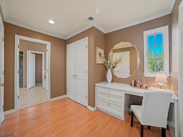 office space featuring visible vents, ornamental molding, built in study area, baseboards, and light wood-style flooring