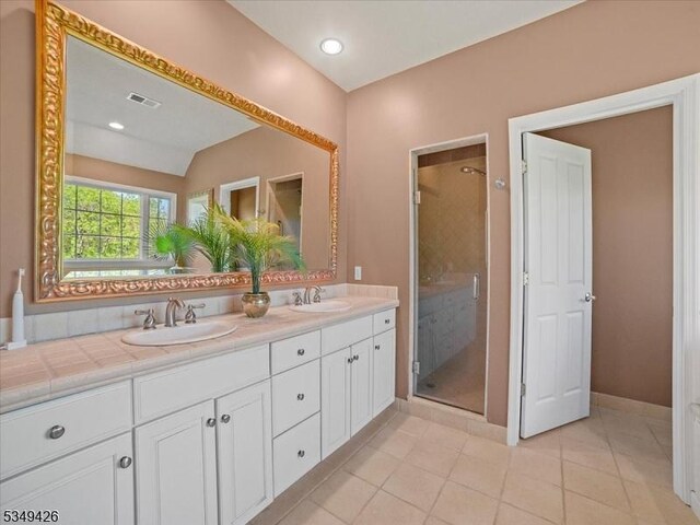 bathroom with visible vents, a shower stall, and a sink
