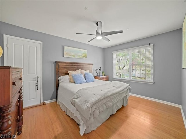 bedroom featuring baseboards, ceiling fan, and light wood-style flooring