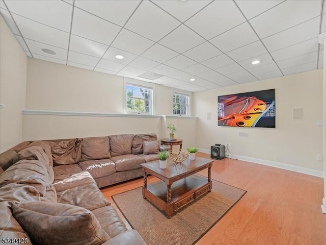 living room with recessed lighting, baseboards, a drop ceiling, and wood finished floors