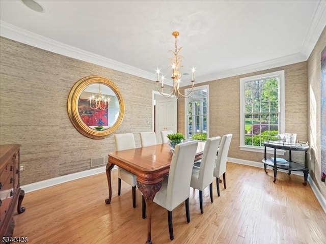 dining room with a notable chandelier, baseboards, wallpapered walls, light wood-type flooring, and visible vents
