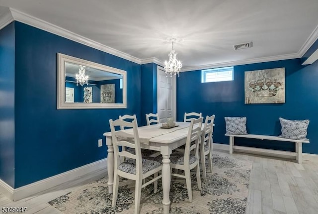 dining space with ornamental molding, baseboards, a chandelier, and wood finished floors